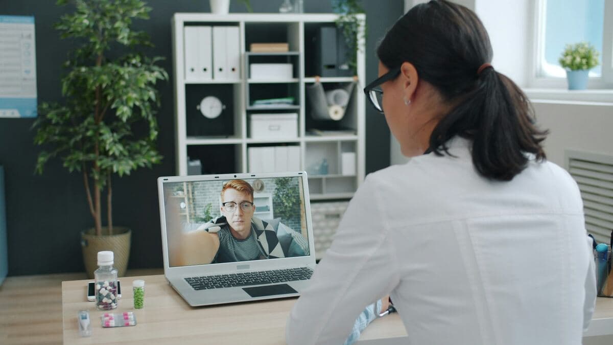 Doctor talking to a patient through a video call from a clinic office
